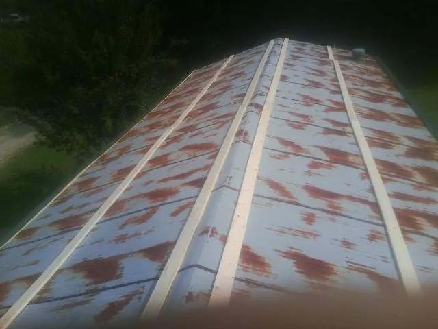 Rusted metal roof panels with new wood purlins before replacement — Storm Damage Roof Repair in Riley by Roofing Brothers