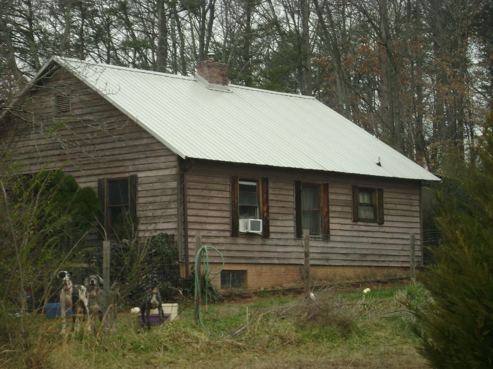 White metal roof on an old wood sided farmhouse, from a Metal Roof Installation job in Riley